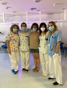 Group of 4 female doctors and nurses with a KMC volunteer in their midst.